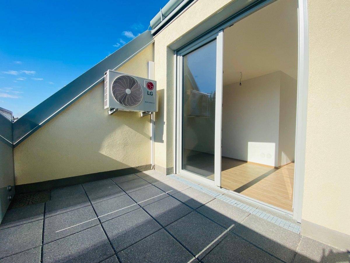 Geräumige Terrasse mit Fliesenboden und Schiebetür zum Innenbereich der Wohnung.