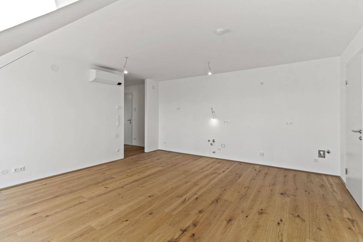 Moderner Wohnraum mit Holzboden, Klimaanlage und Anschlussmöglichkeiten für Elektronik.