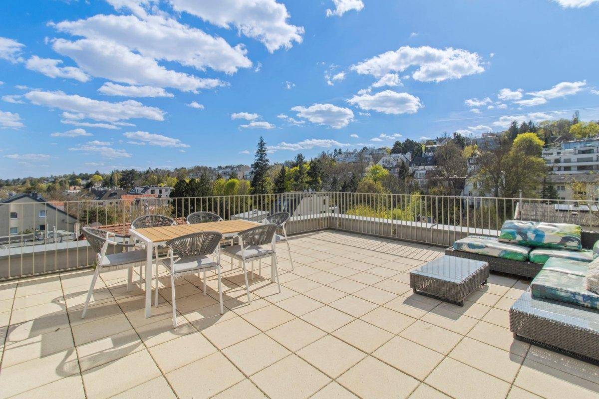 Große Dachterrasse mit Essbereich, Lounge-Möbeln und weitem Blick über die Stadt.