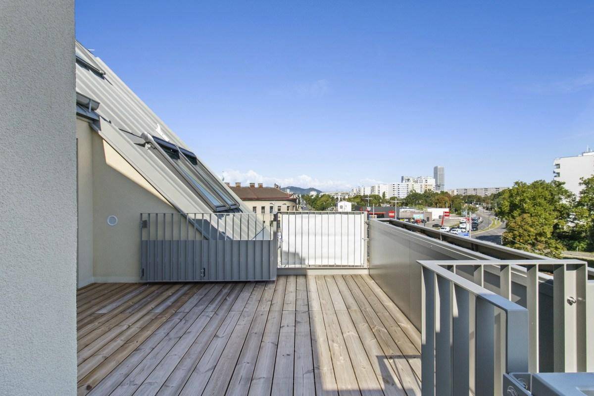 Geräumige Dachterrasse mit Holzboden und weitem Blick über die Stadt und die Umgebung.