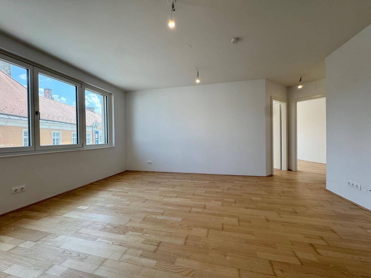Heller Raum mit Parkettboden und Zugang zu weiteren Zimmern, ideal für individuelle Gestaltung.