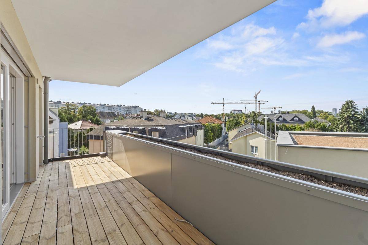 Unmöblierter Balkon mit Holzboden und Panoramablick über die städtische Umgebung.