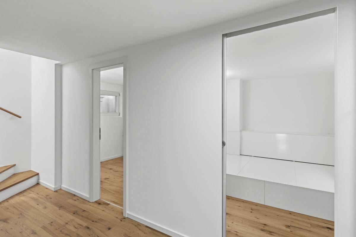 Heller Flur mit Holzfußboden und Zugang zu weiteren Räumen im modernen Stil.