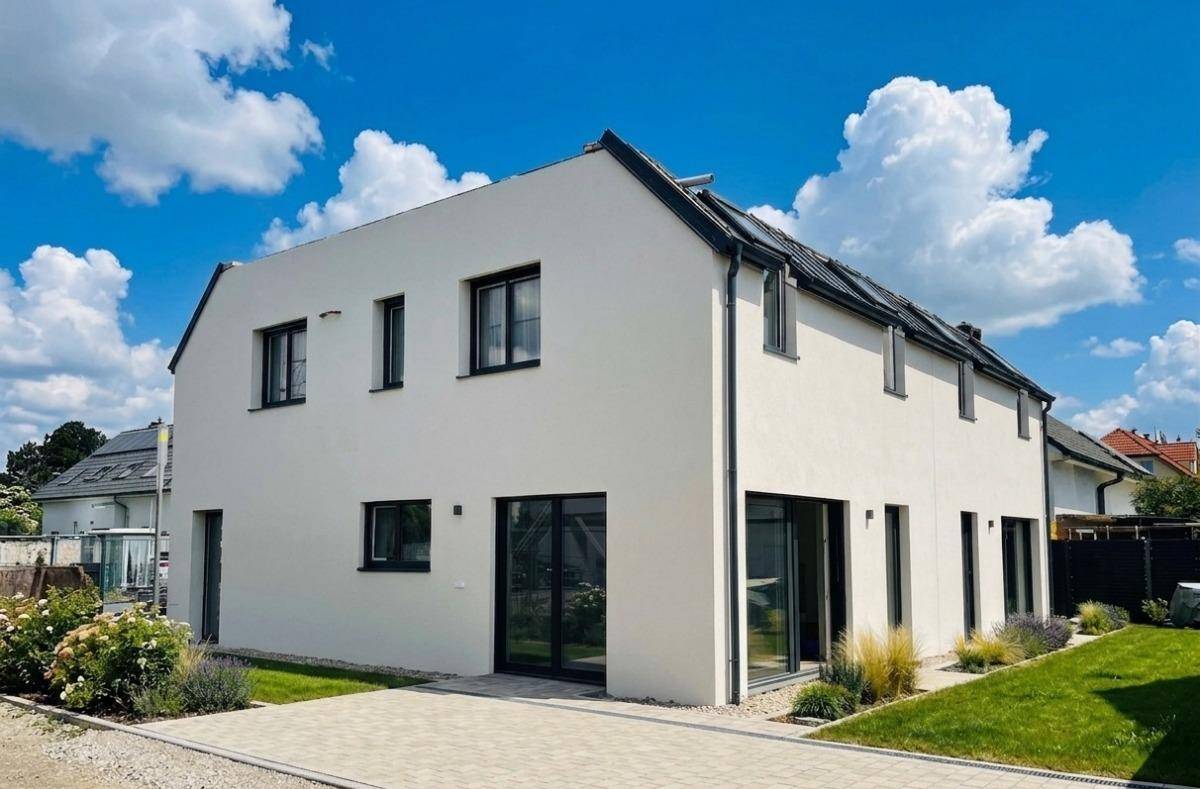 Rückseite der modernen Reihenhäuser mit großen Glasfronten und Zugang zum Gartenbereich.