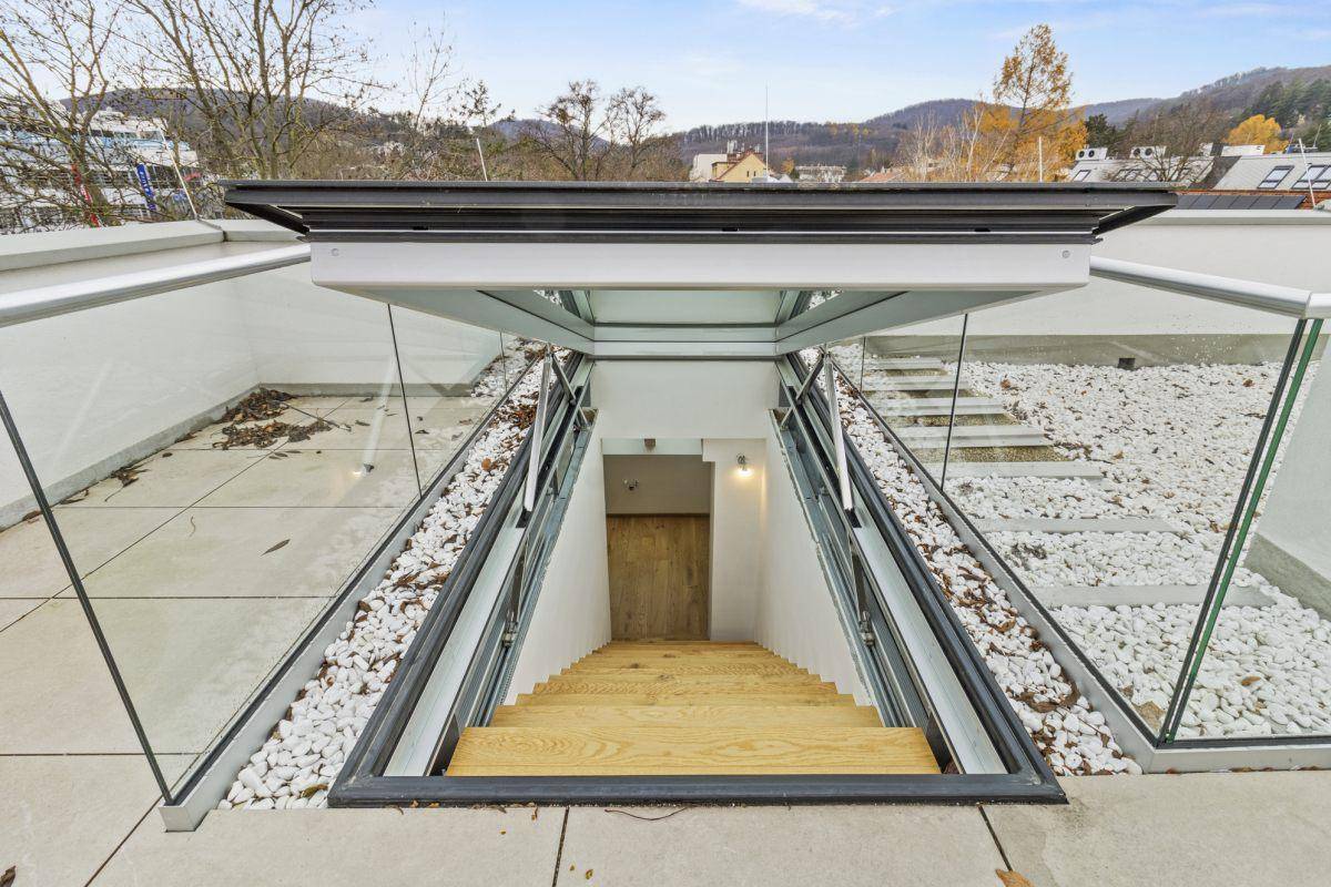 Zugang zur Dachterrasse mit moderner Glasüberdachung und Treppe in einem Neubau.