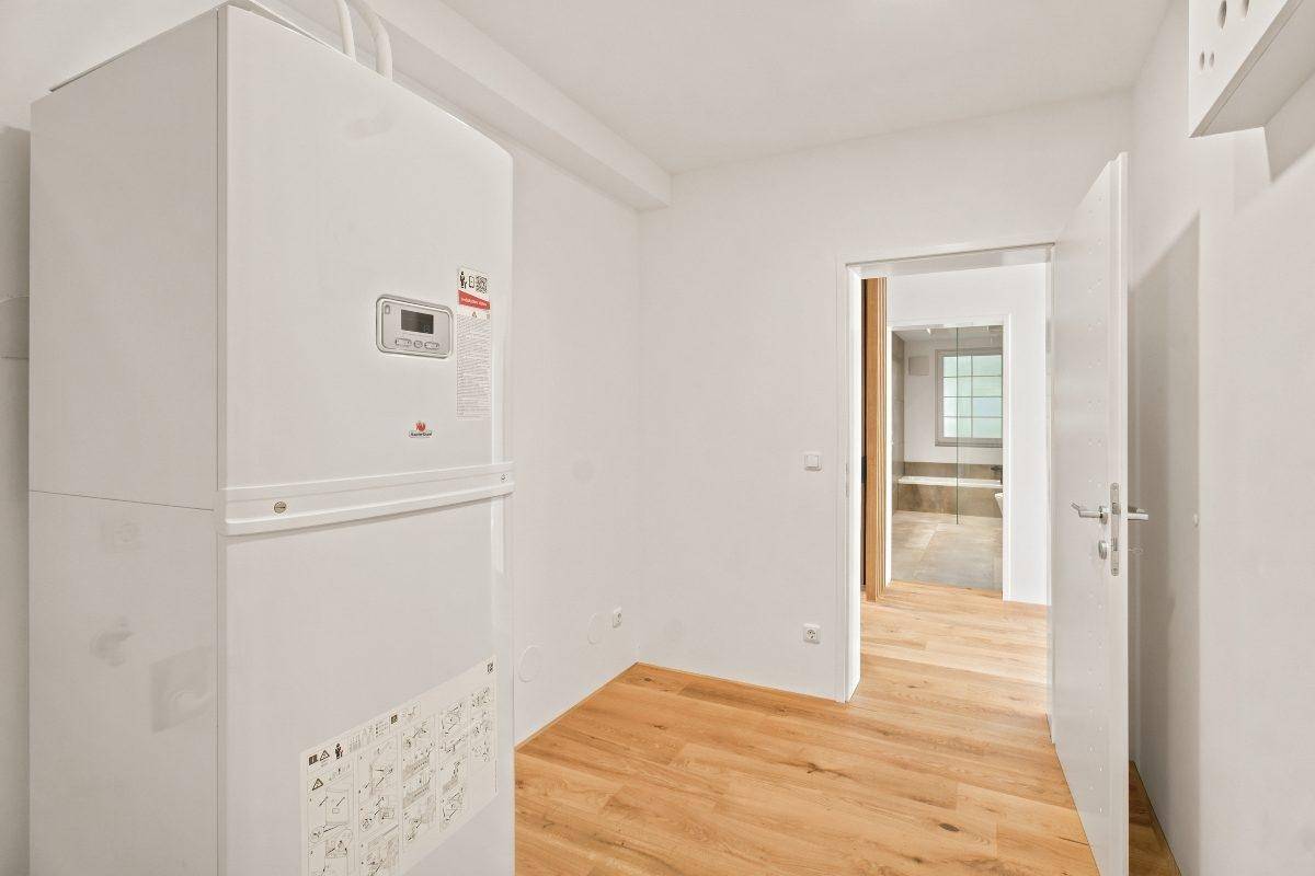 Hauswirtschaftsraum mit Heizungsanlage und Zugang zu einem weiteren Raum.