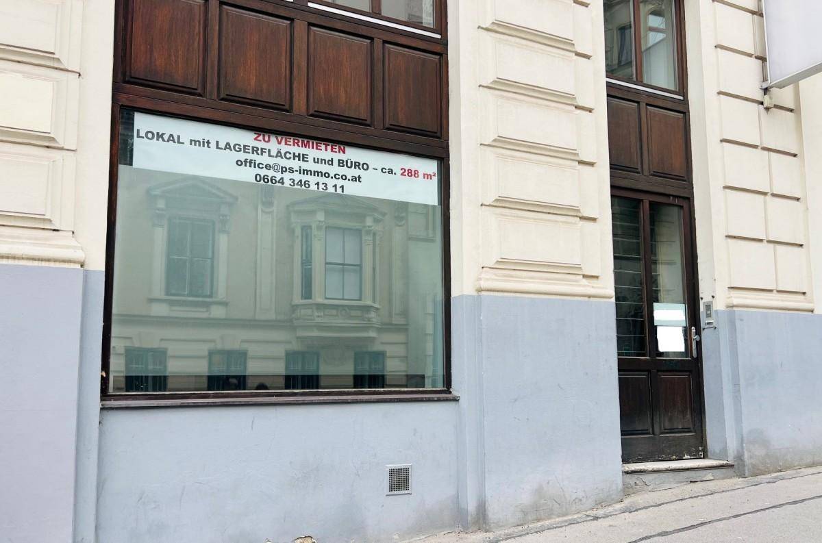 Nahaufnahme der Fassade eines Altbaus mit einem 'Zu vermieten'-Schild im Fenster, gut sichtbar.