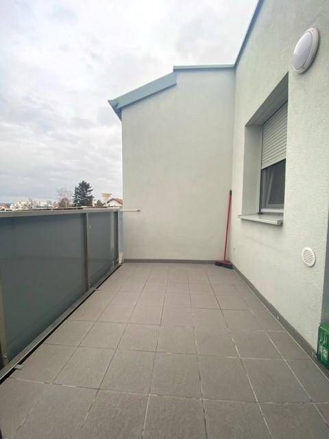 Geräumiger Balkon mit Fliesenboden und Glasgeländer, ideal für entspannte Stunden im Freien.
