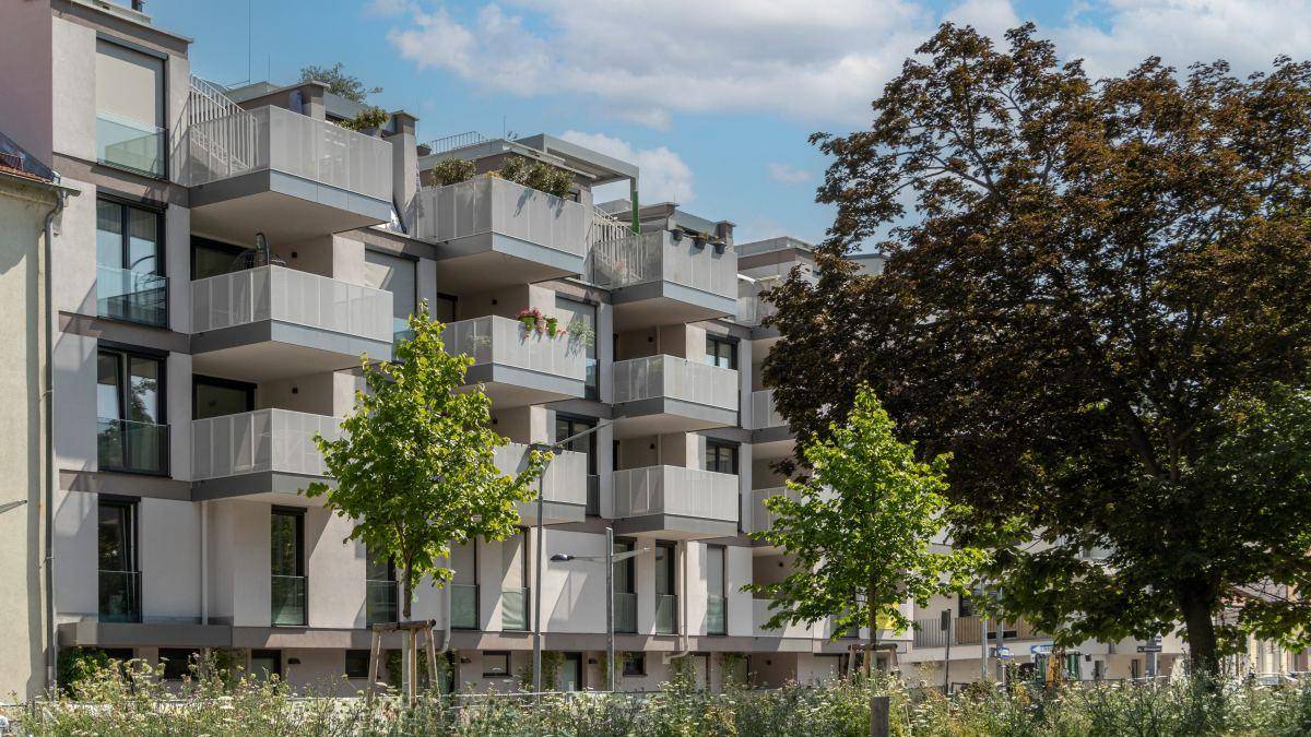 Ansicht eines modernen Wohngebäudes mit zahlreichen Balkonen und großen Fenstern.
