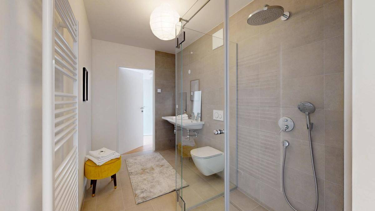 Modernes Badezimmer mit ebenerdiger Dusche, Wand-WC und beheiztem Handtuchhalter.