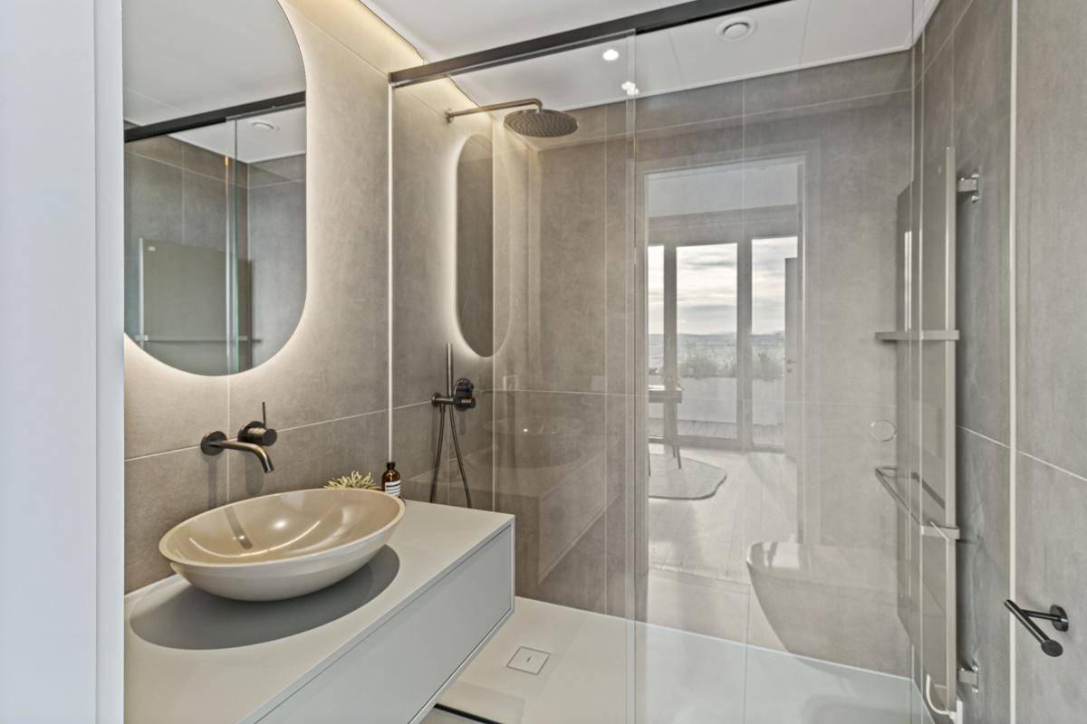 Modernes Badezimmer mit begehbarer Dusche, Einzelwaschbecken und stilvoller Beleuchtung.