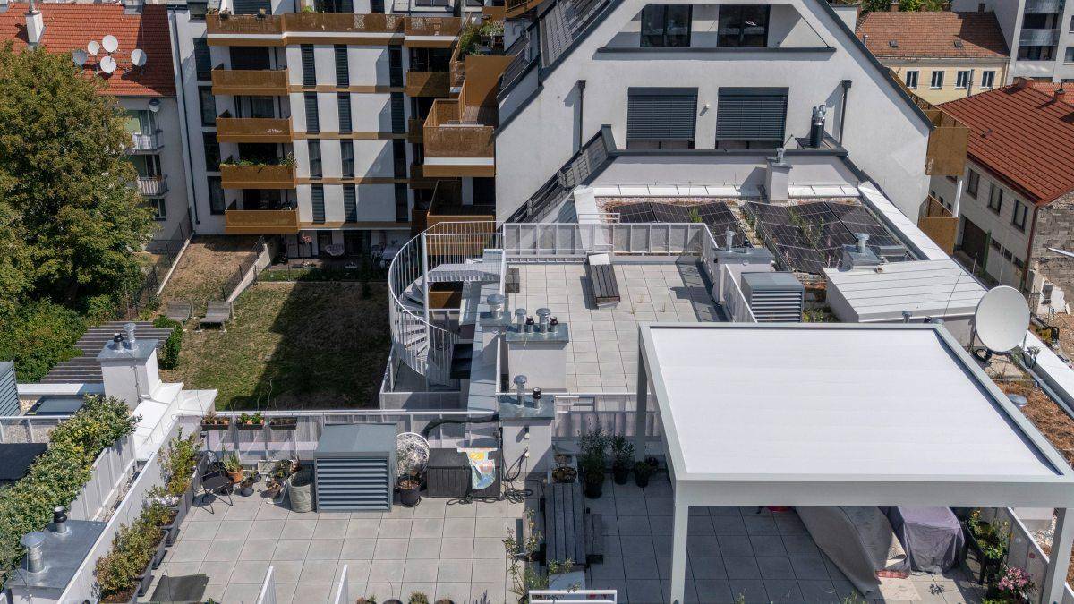Vogelperspektive auf das Gebäude mit mehreren Dachterrassen und einer Wendeltreppe.