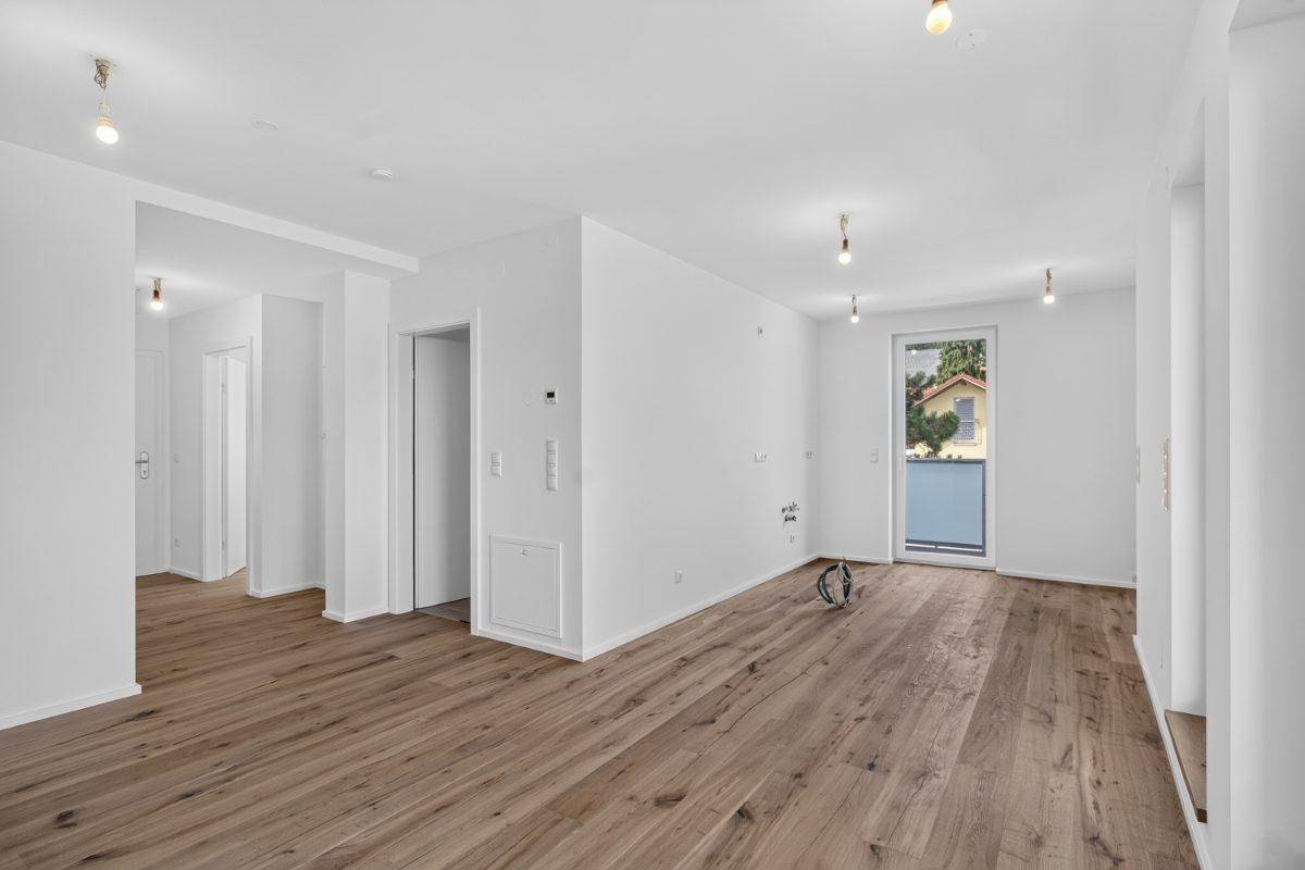 Heller Wohnraum mit Holzboden und direktem Zugang zum Aufzug, ideal für modernes Wohnen.