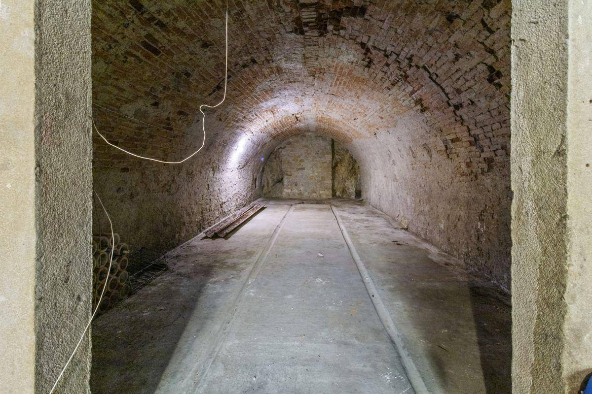 Historischer Gewölbekeller mit Ziegelwänden und robustem Betonboden.