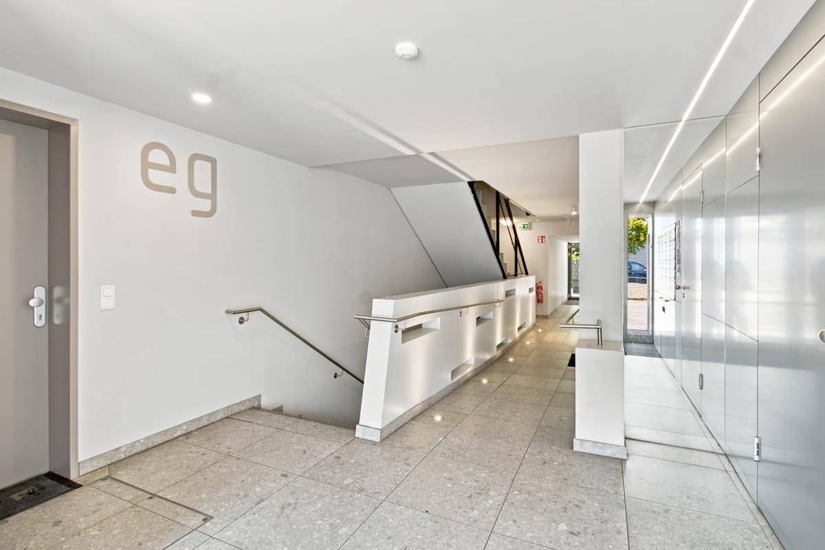 Heller Treppenhausbereich im Erdgeschoss mit modernem Design und Fliesenboden.