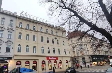 Historische Fassade des Gebäudes von der Straße aus gesehen mit Geschäften im Erdgeschoss.