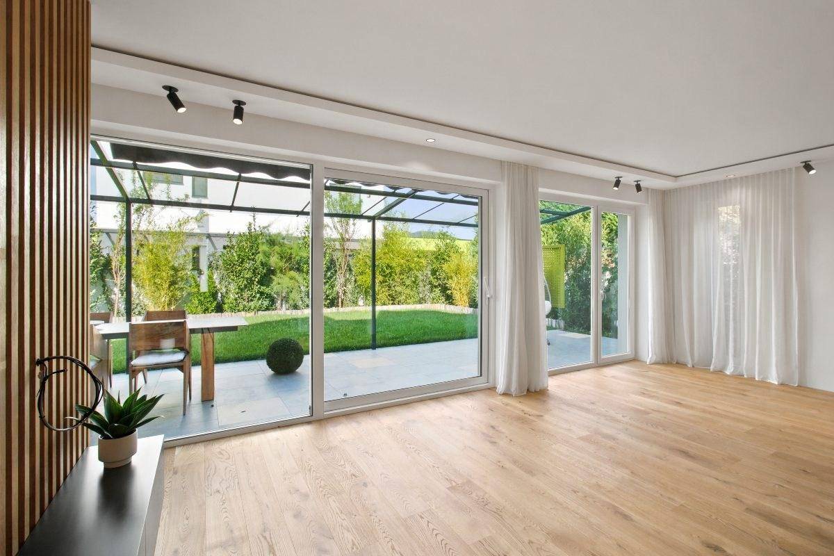 Heller Wohnbereich mit großen Schiebetüren, die zum Garten und zur Terrasse führen.