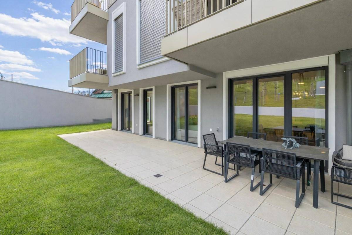 Geräumige Terrasse mit modernen Gartenmöbeln und direktem Zugang zum gepflegten Rasenbereich.