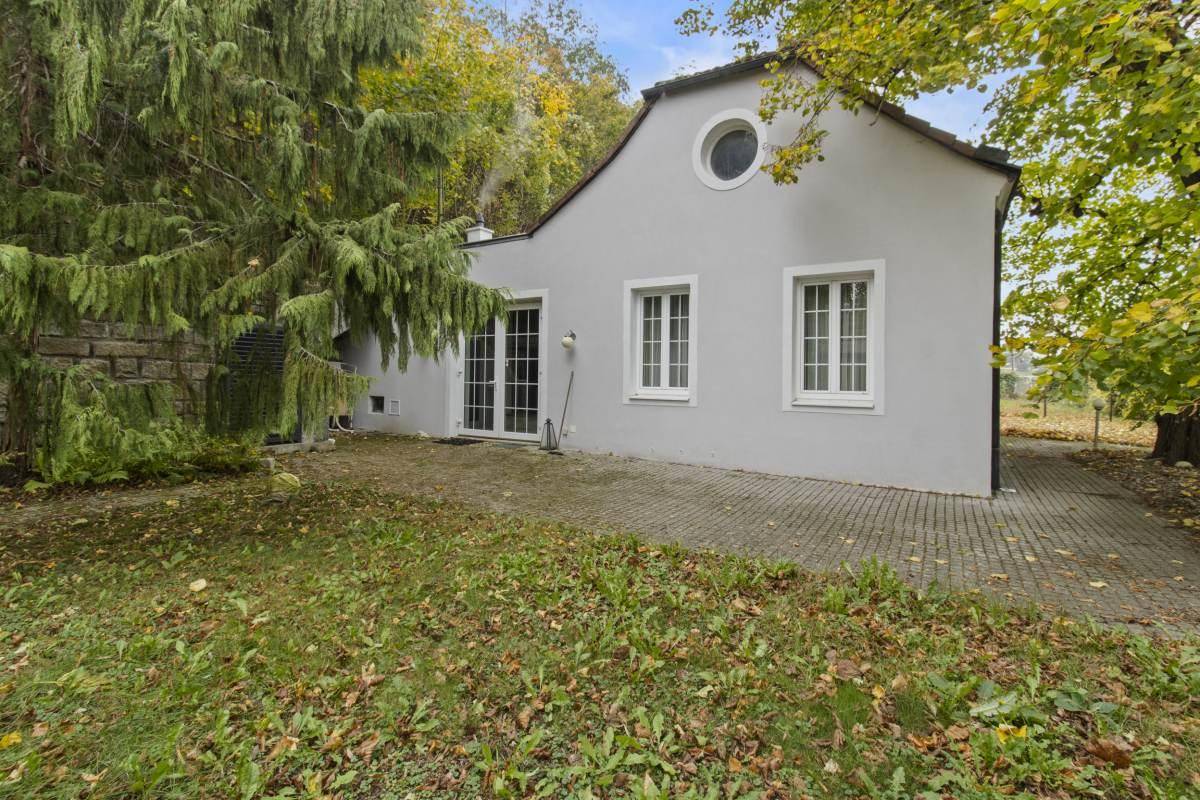 Rückseite des Hauses mit Terrassenzugang, gepflastertem Bereich und Garten.
