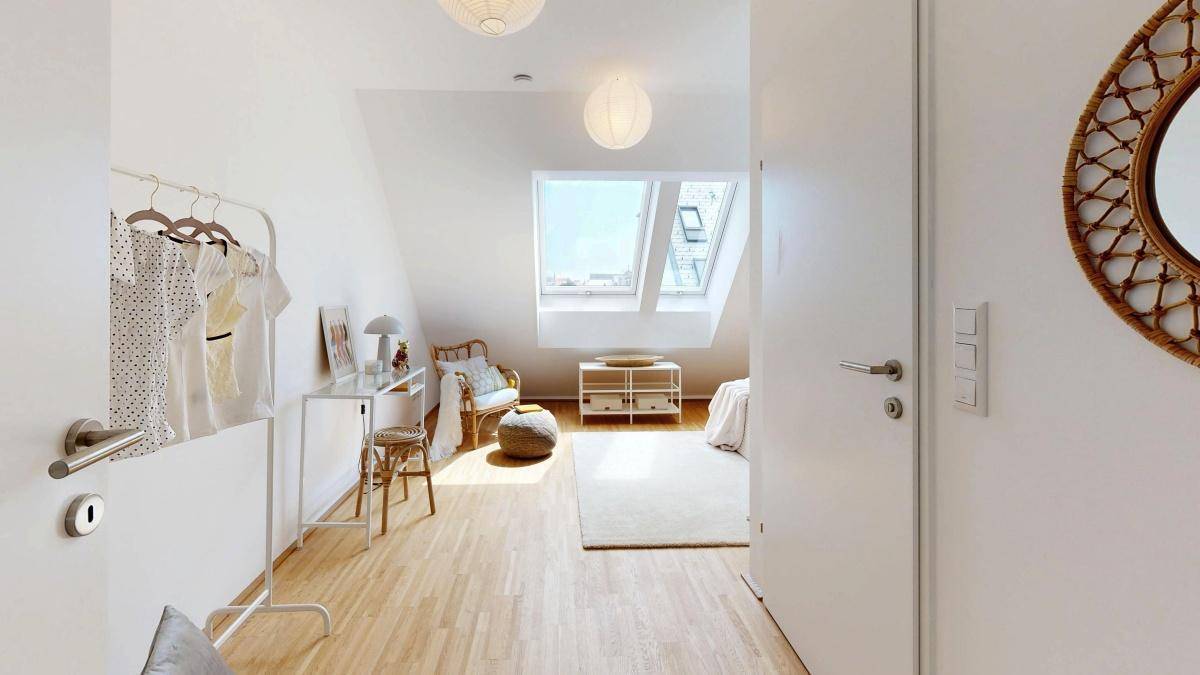 Helles Schlafzimmer mit Dachschrägen, Dachfenstern und modernem Interieur.