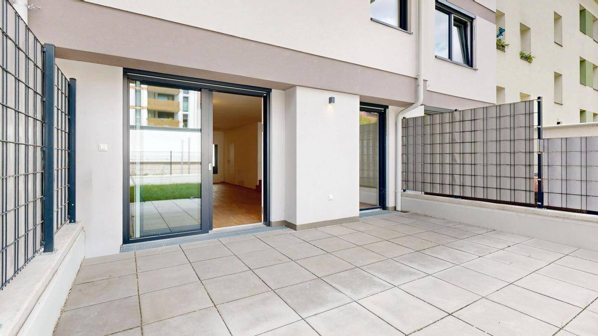 Geräumige, geflieste Terrasse mit Zugang zum Garten und Blick auf die Umgebung.