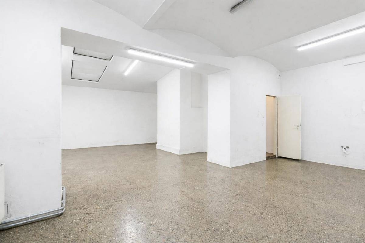 Leerer, heller Gewerberaum mit hohen Decken und einem polierten Betonboden, bereit zur individuellen Gestaltung.
