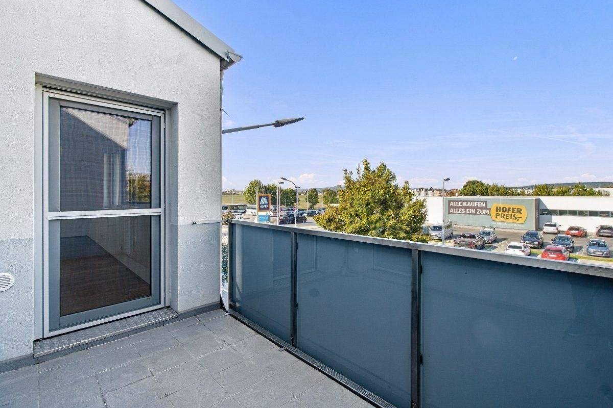Geräumiger Balkon mit Glasbrüstung und Blick auf die Umgebung.