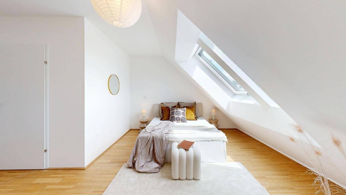 Geräumiges Schlafzimmer mit Dachschrägen, Dachfenster und minimalistischer Einrichtung.