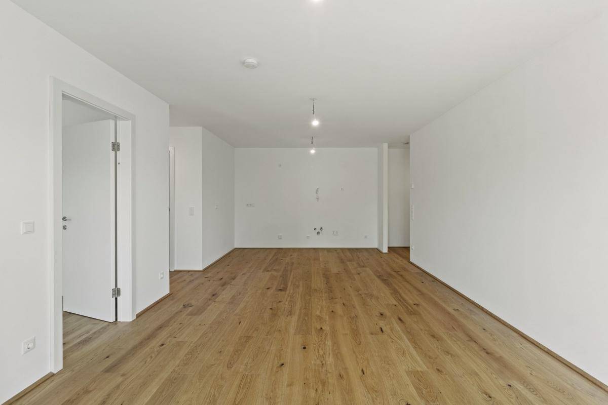 Leerer, heller Raum mit Holzboden, bereit für individuelle Gestaltung.