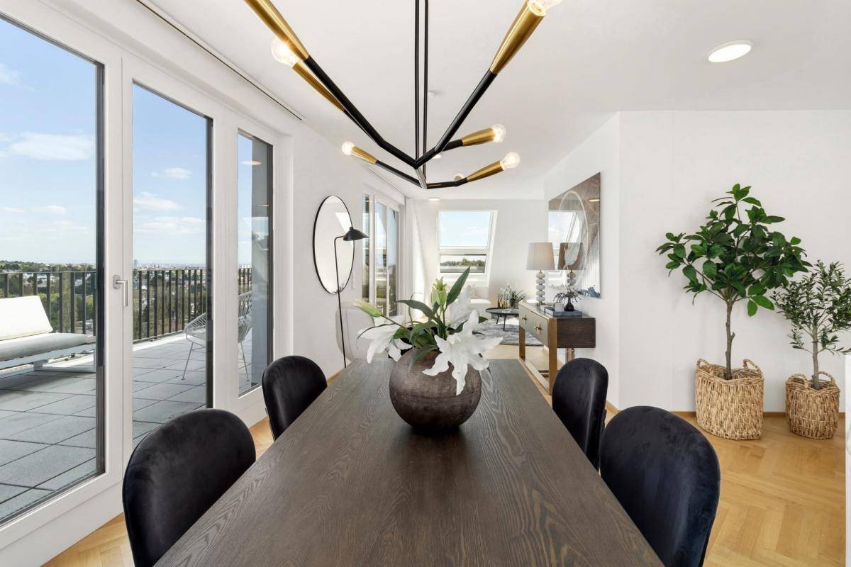 Eleganter Essbereich mit großem Holztisch und Zugang zur sonnigen Terrasse mit Aussicht.