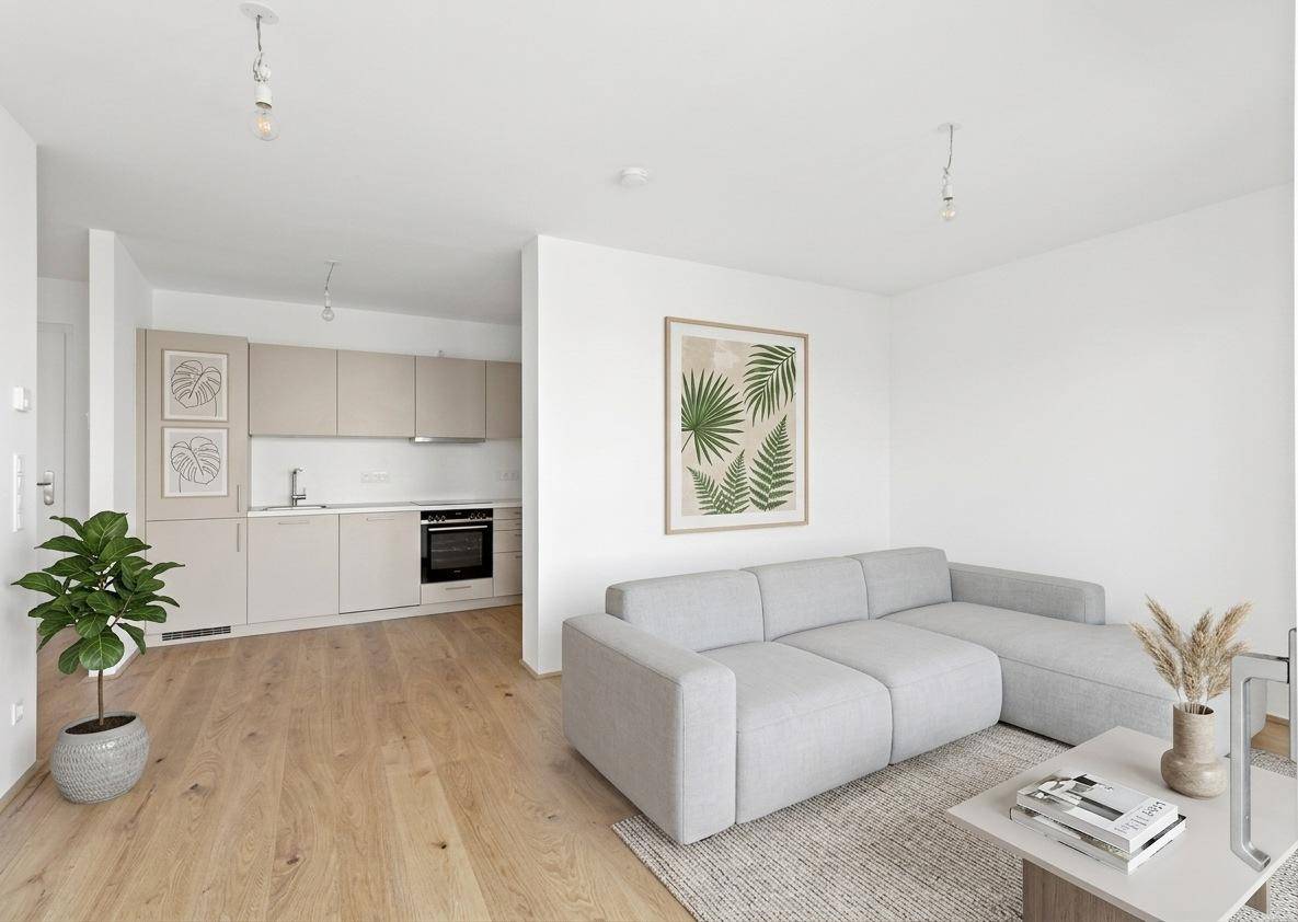 Heller Wohnbereich mit offener Küche, Parkettboden und modernem Sofa.