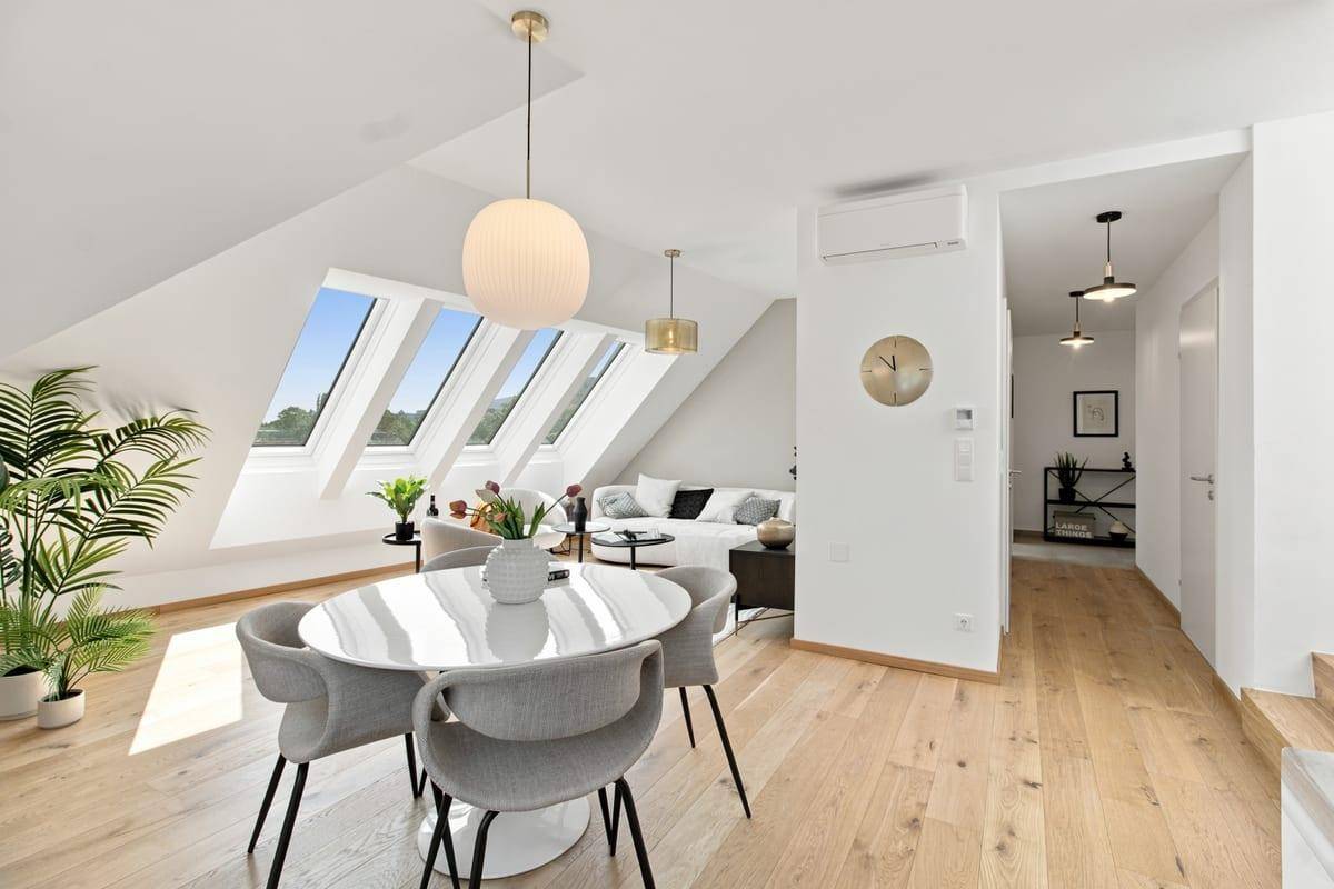 Geräumiger Wohn-Essbereich mit Holzboden, Dachfenstern und modernem Interieur.