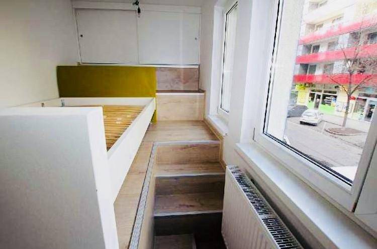 Schlafbereich mit Hochbett-Konstruktion, Fensterblick auf die Straße und Heizkörper.