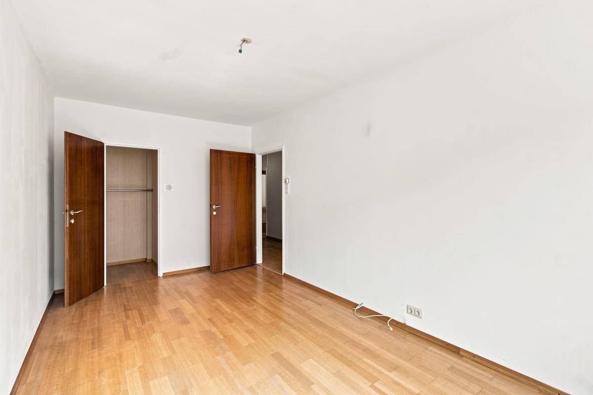 Geräumiges Schlafzimmer mit Holzboden und Zugang zu einem Einbauschrank.