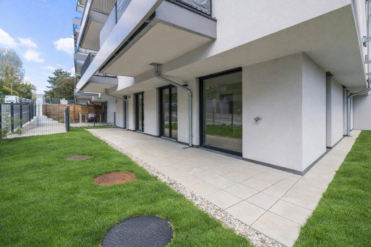 Erdgeschoss-Terrasse mit Fliesenboden und direktem Zugang zum Gartenbereich.