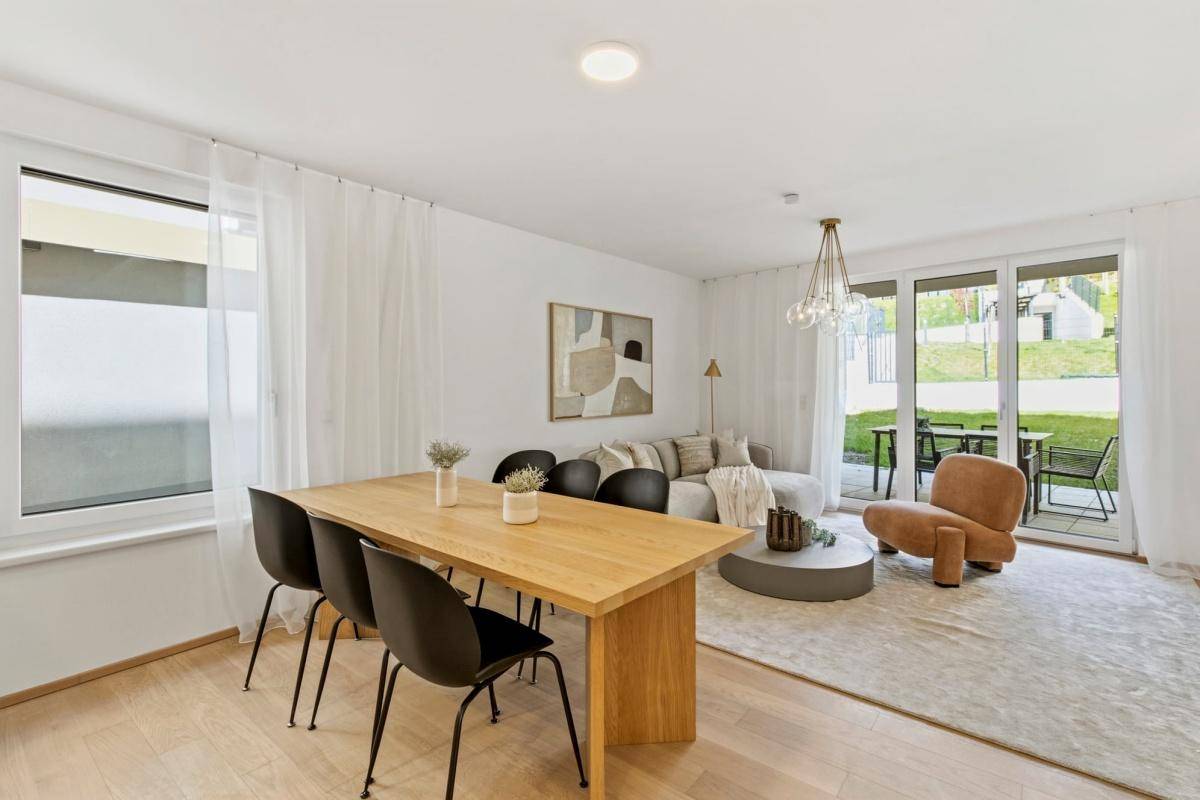 Lichtdurchfluteter Wohn- und Essbereich mit Holztisch und modernem Interieur.