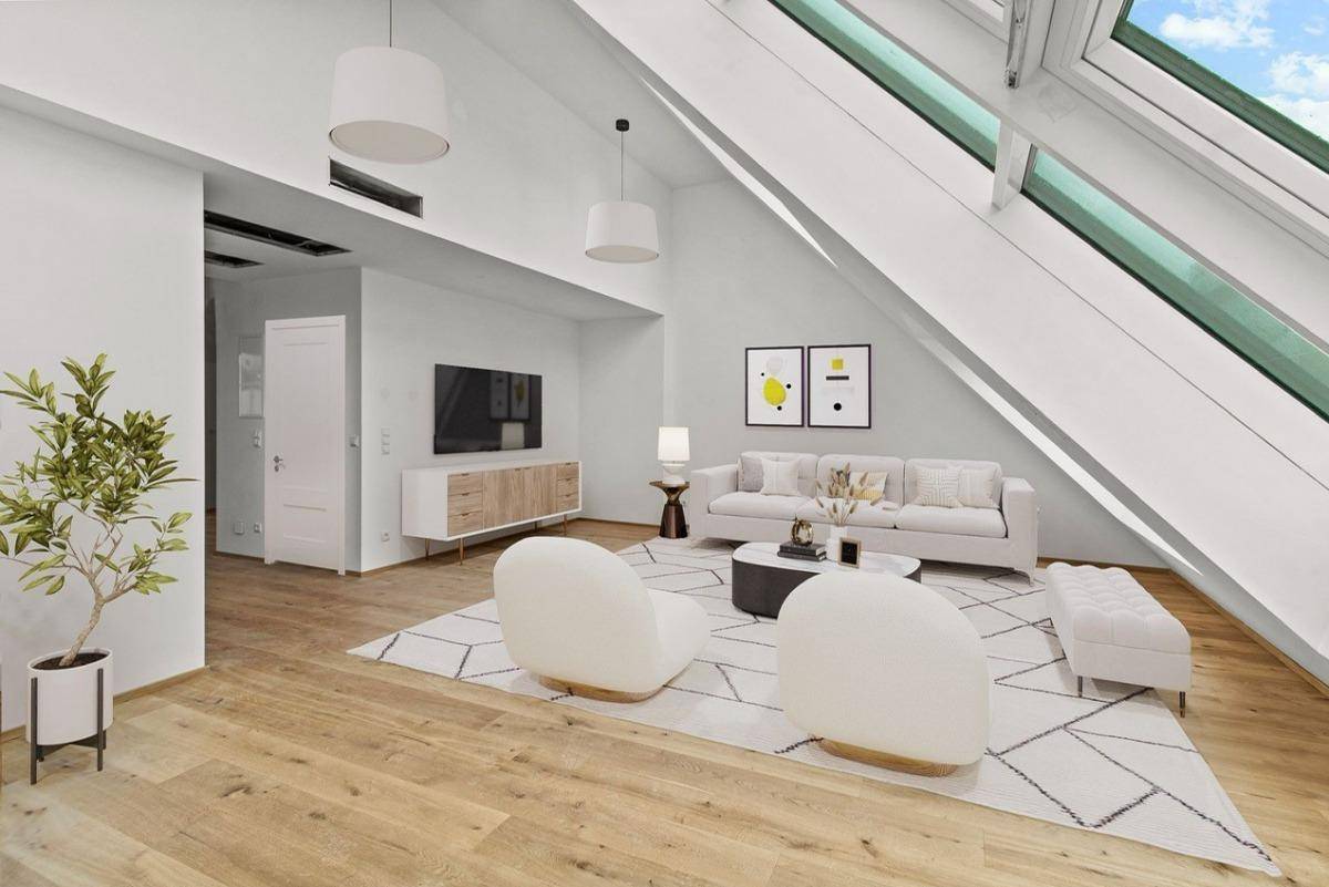 Modern eingerichtetes Wohnzimmer mit Holzboden, schrägen Wänden und großen Dachfenstern für viel Licht.