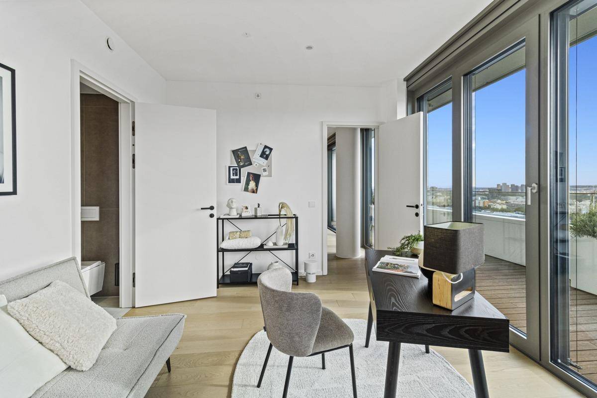 Geräumiges Arbeitszimmer mit großen Fenstern, die viel Tageslicht hereinlassen und Weitblick bieten.