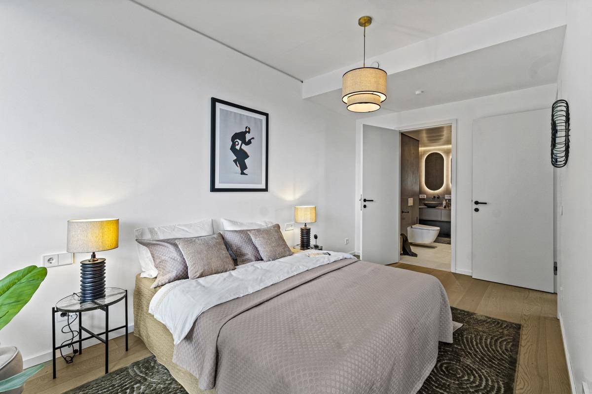 Helles Schlafzimmer mit direktem Zugang zu einem modernen Badezimmer.