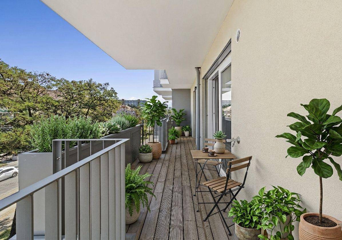 Geräumiger Balkon mit Holzboden, Pflanzen und Sitzgelegenheiten, bietet einen grünen Ausblick.