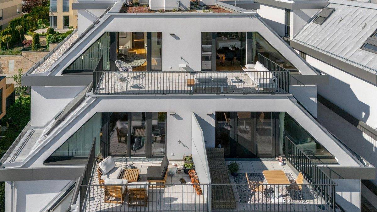 Moderne Architektur mit mehreren Terrassen und Balkonen auf verschiedenen Ebenen.