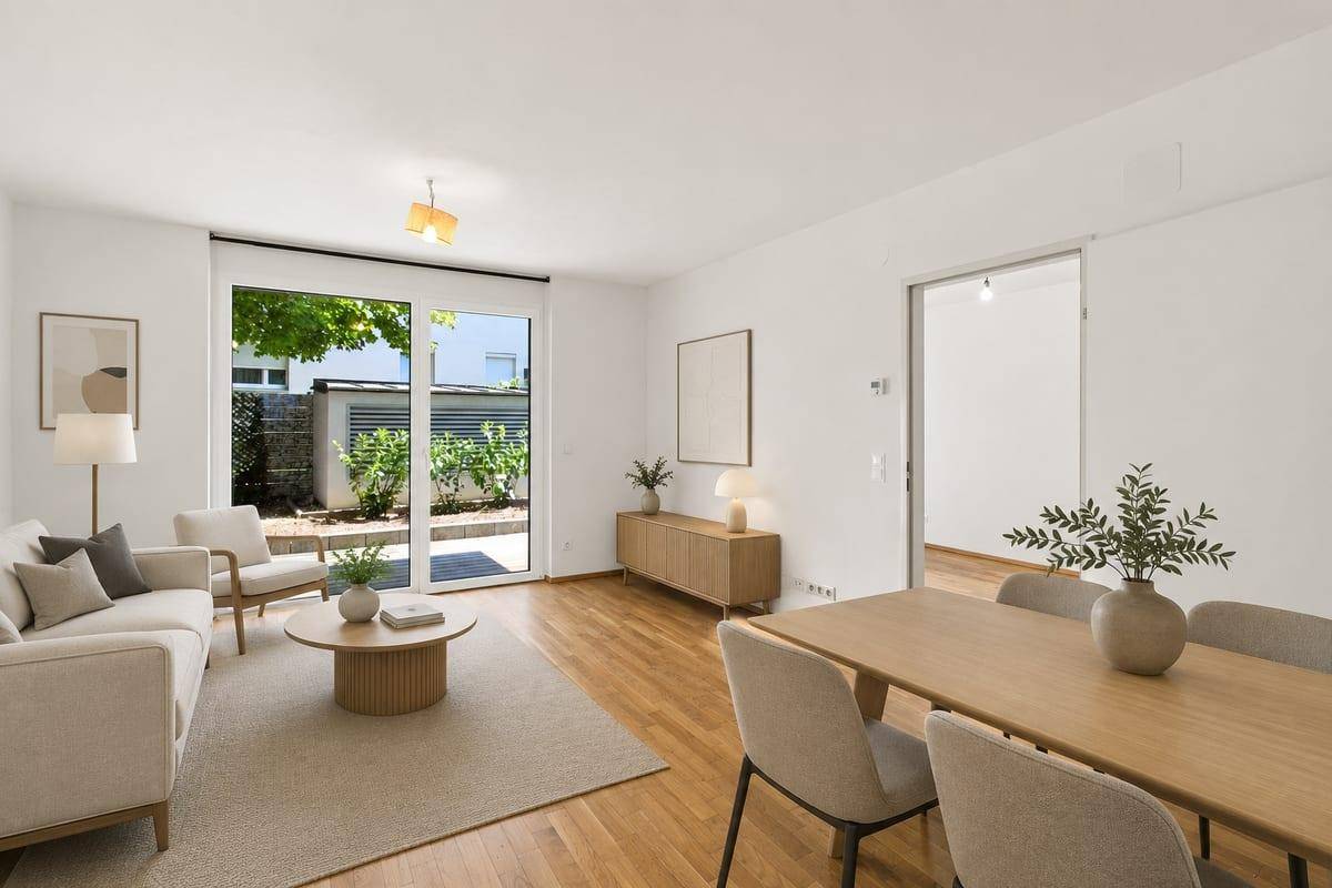 Heller Wohn- und Essbereich mit Holzboden, Zugang zur Terrasse und moderner Einrichtung.