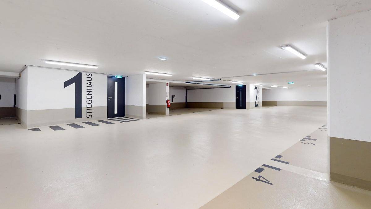 Geräumige Tiefgarage mit nummerierten Stellplätzen und hellem Boden.