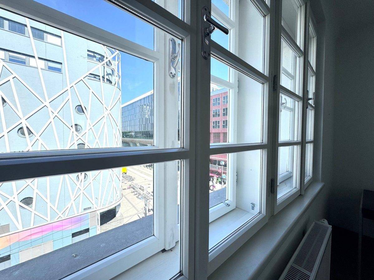 Fenster mit Blick auf moderne Architektur und die belebte Stadtlandschaft.