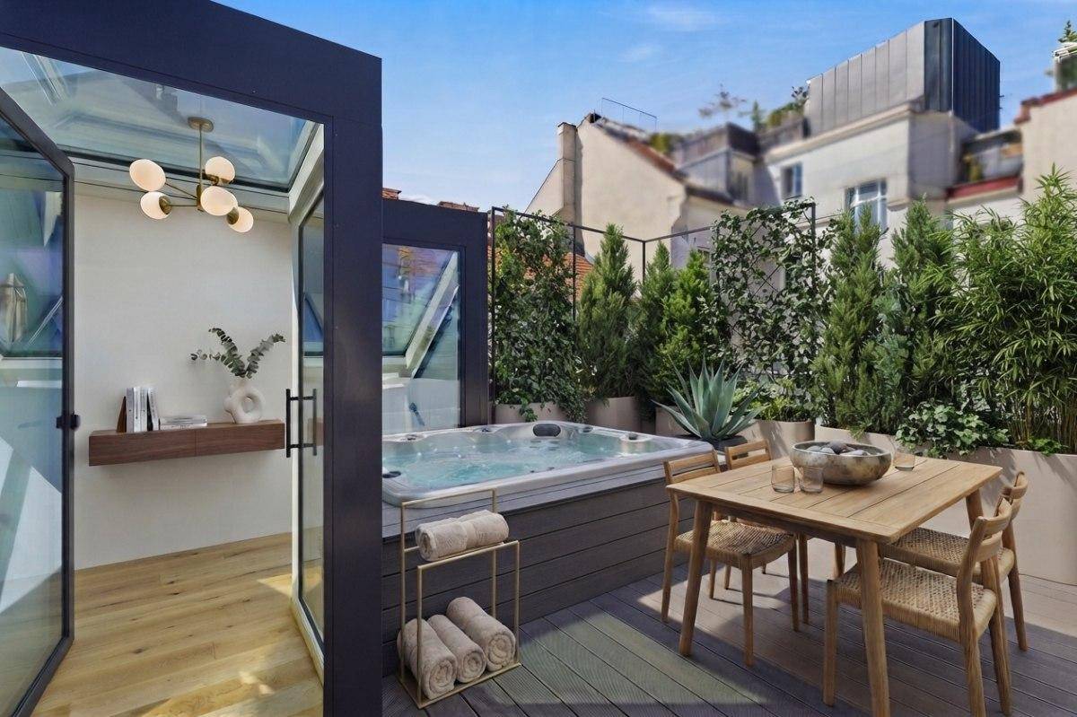 Exklusive Dachterrasse mit Whirlpool, Essbereich und grüner Bepflanzung.