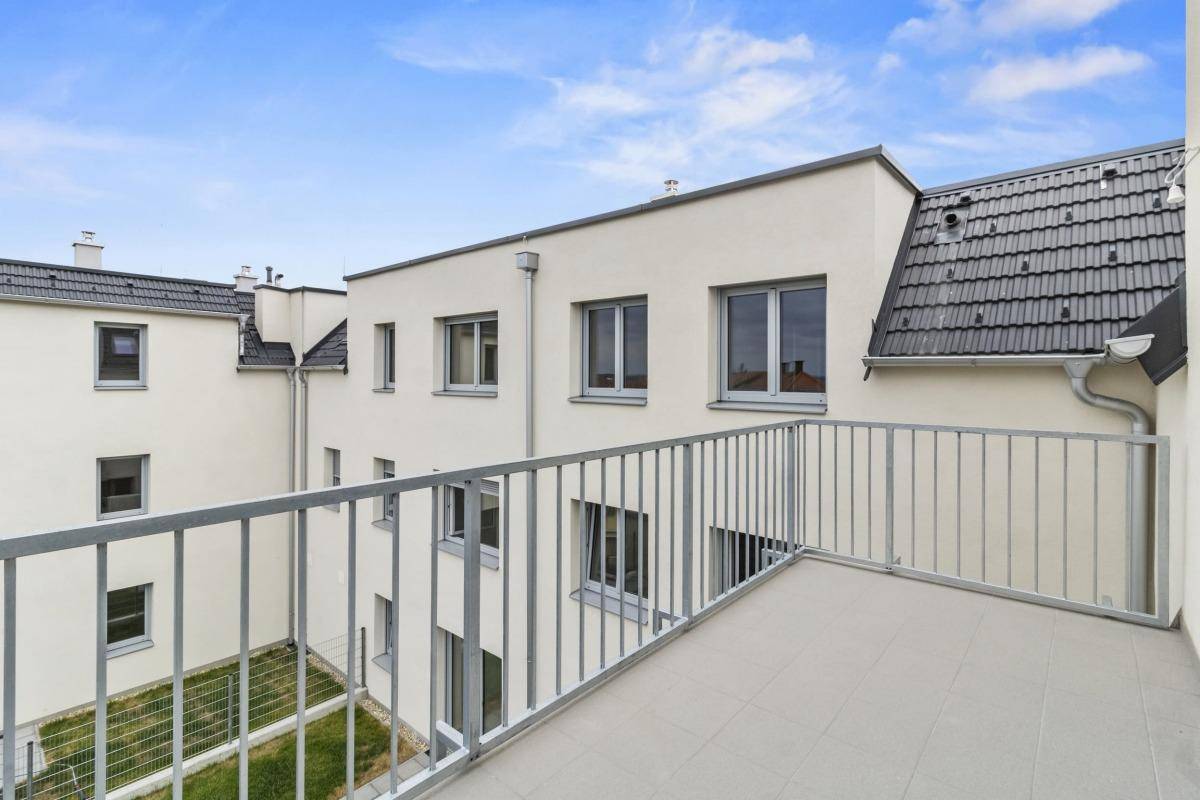 Balkon mit Blick auf den Innenhof der Wohnanlage und die umliegenden Gebäude.