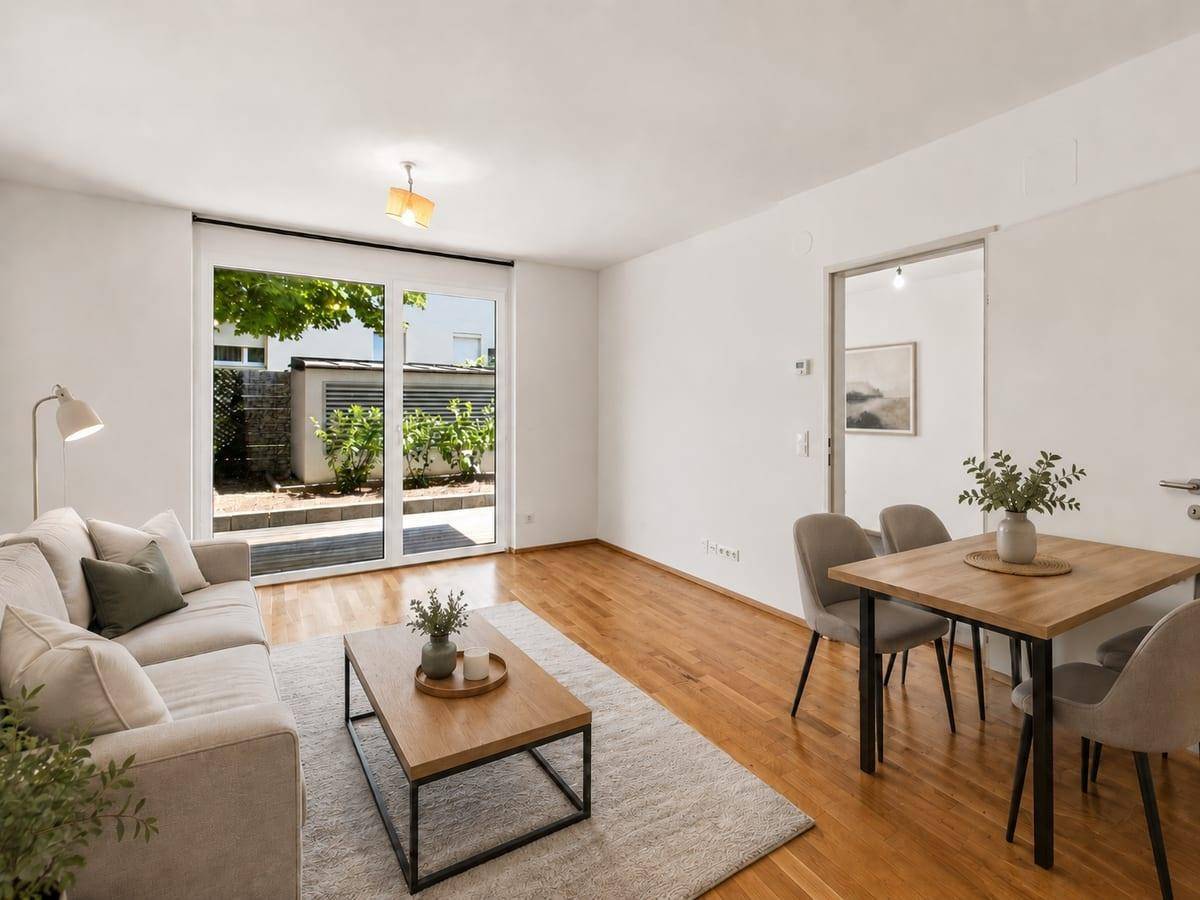 Stilvoller Wohn- und Essbereich mit Holzboden, modernen Möbeln und Zugang zur Terrasse.