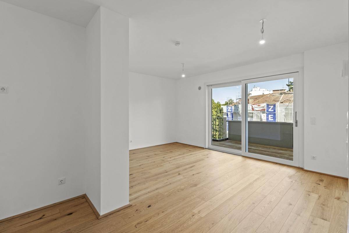 Heller Wohnraum mit Parkettboden und direktem Zugang zu einem Balkon.