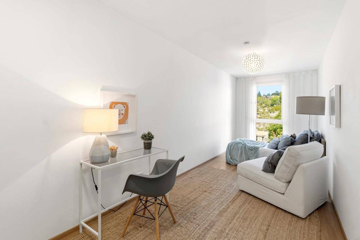 Helles Arbeitszimmer mit Schreibtisch, bequemer Liege und Blick ins Grüne.