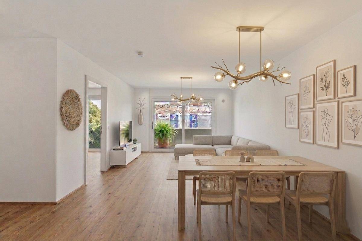 Geräumiger Wohn- und Essbereich mit Holzboden, stilvoller Beleuchtung und Zugang zum Balkon.